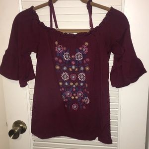 Off the shoulder maroon shirt.